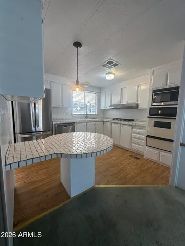 a kitchen with kitchen island granite countertop a stove a sink and a refrigerator