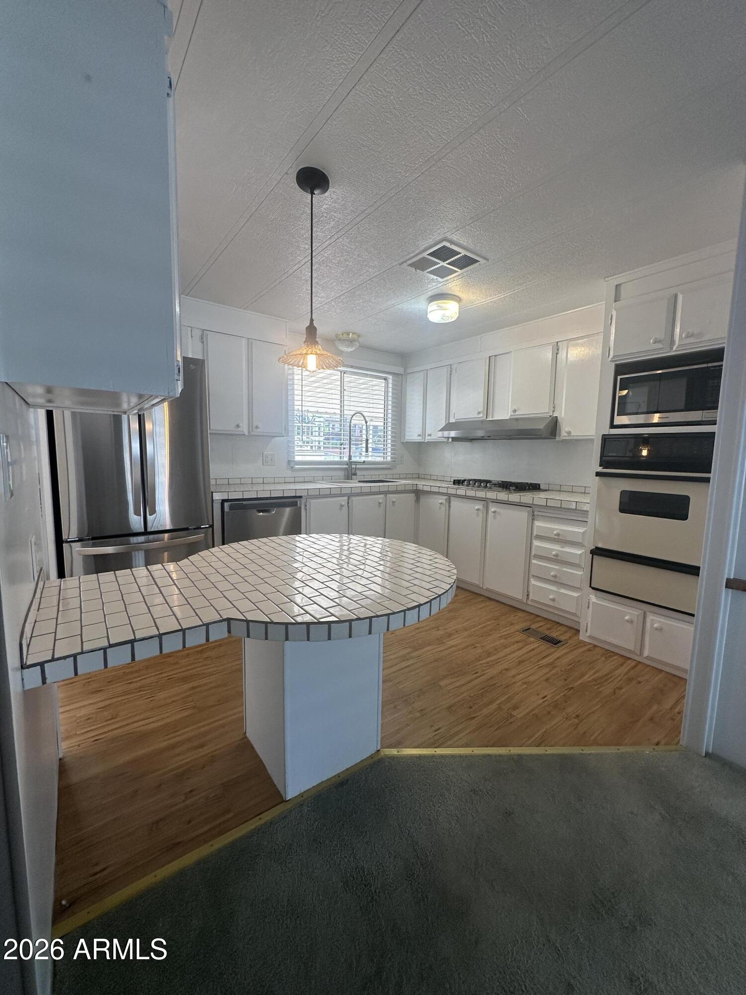 205 Sunset Drive, Unit 108 Sedona, AZ 86336 - Photo 9 of 16 a kitchen with kitchen island granite countertop a stove a sink and a refrigerator