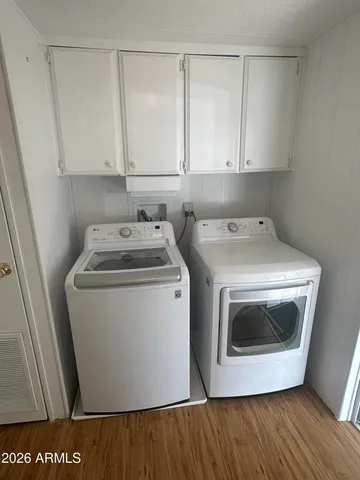 a utility room with wooden floor washer and dryer