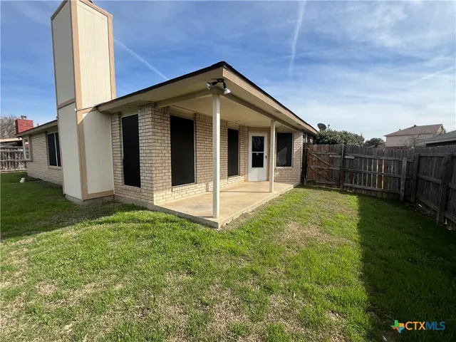 a view of a house with backyard and porch