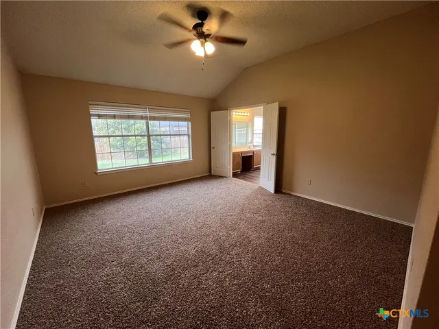an empty room with closet and a ceiling fan