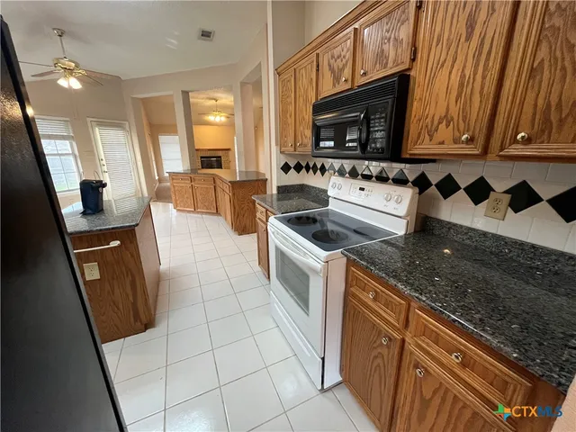 a kitchen with granite countertop a refrigerator and a sink