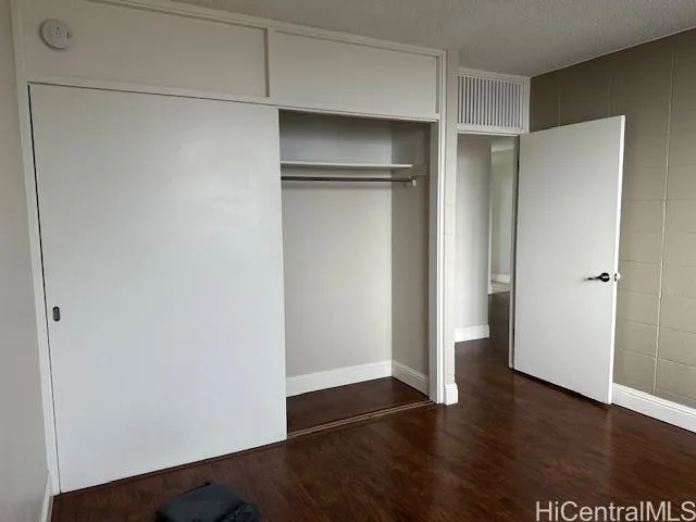 a view of an empty walk in closet with wooden floor