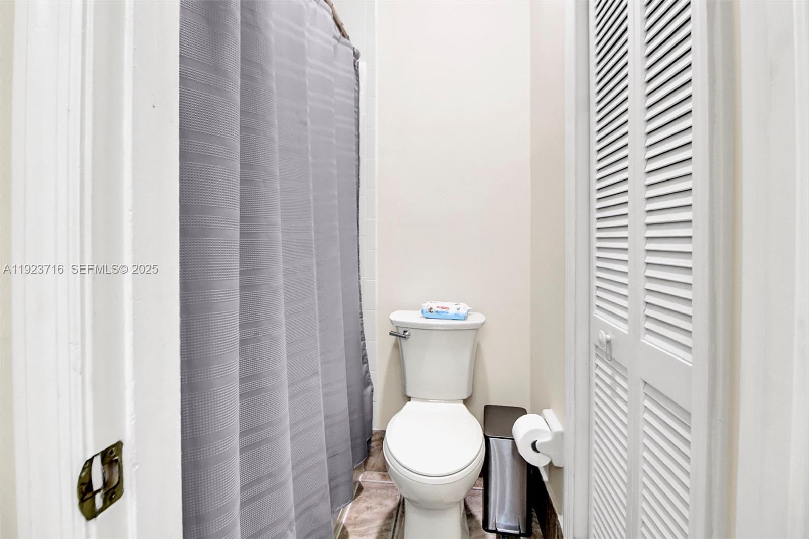15875 Southwest 149th Lane Miami, FL 33196 - Photo 17 of 32 a white toilet sitting next to a shower curtain