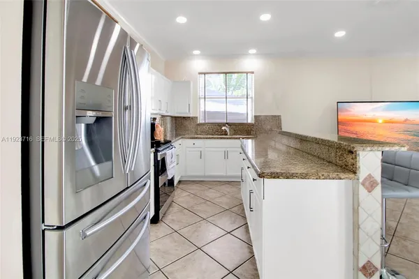 a kitchen with granite countertop a refrigerator and a sink