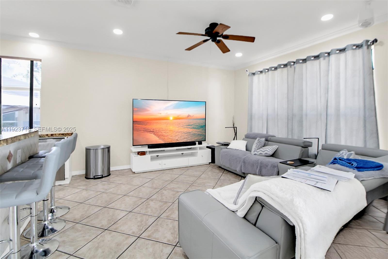 15875 Southwest 149th Lane Miami, FL 33196 - Photo 6 of 32 a living room with furniture a rug and a flat screen tv