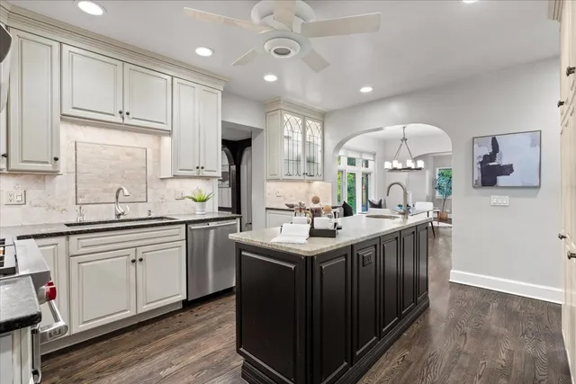 a living room with stainless steel appliances granite countertop furniture a fireplace a flat screen tv and a window