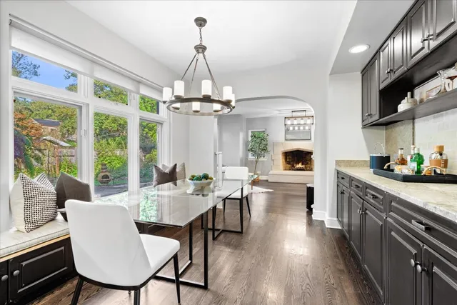 a kitchen with stainless steel appliances kitchen island granite countertop a dining table chairs sink and cabinets