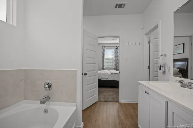 a en suite bathroom with a tub sink and mirror