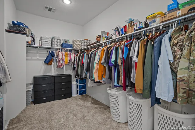 a view of walk in closet with clothes