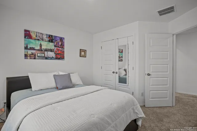 a bedroom with a bed and a painting on the wall