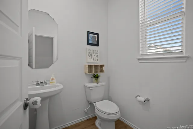 a bathroom with a sink mirror toilet and a window