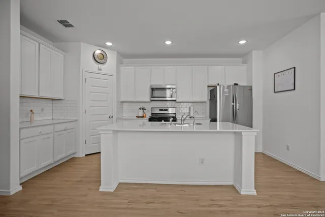 a kitchen with stainless steel appliances granite countertop a stove a sink and a refrigerator