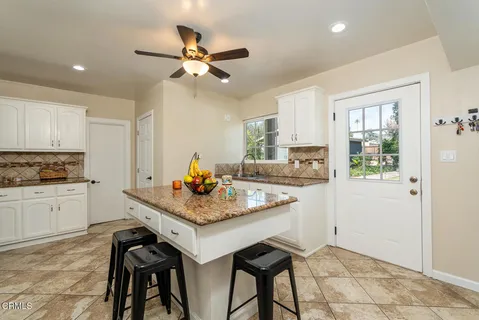 a kitchen with a table chairs sink and cabinets