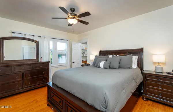 a bedroom with bed window and a mirror on dresser