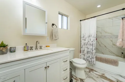 a bathroom with a granite countertop sink a toilet and a mirror