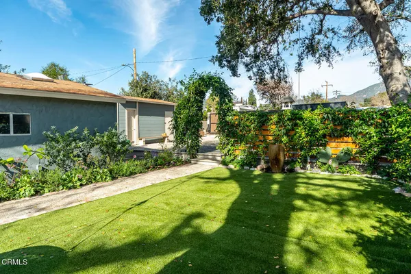 a view of a house with a yard and potted plants