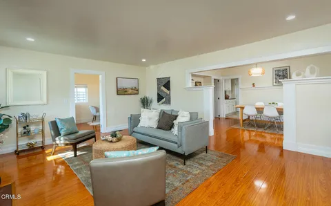 a living room with furniture and a wooden floor