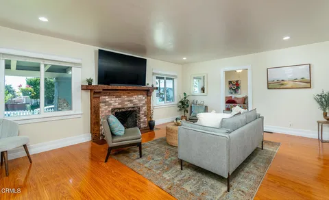 a living room with furniture a flat screen tv and a fireplace