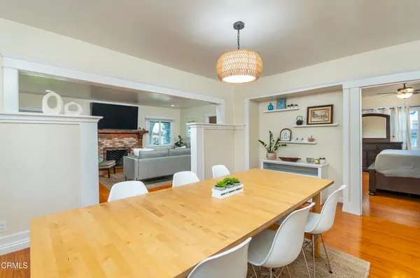 a kitchen and a dining table with wooden floor