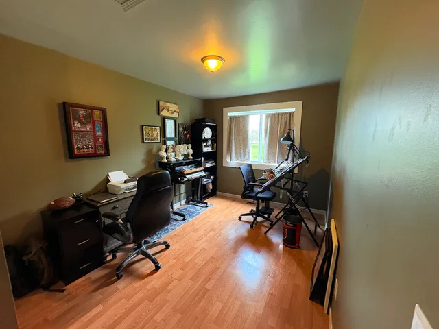 a view of a workspace with furniture and a window