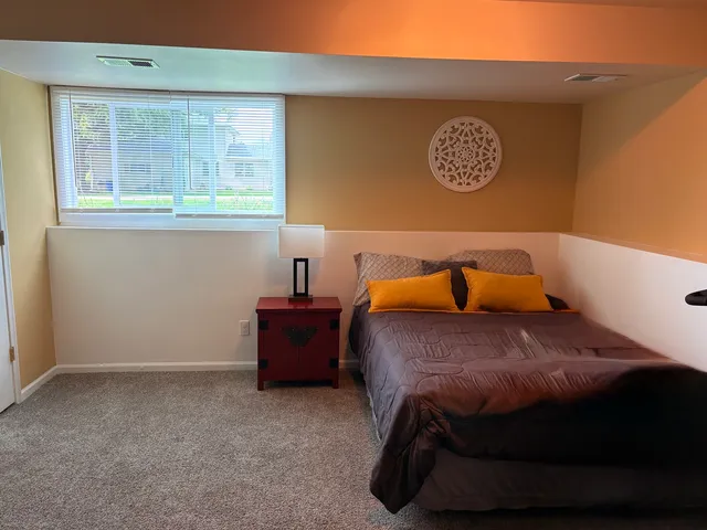 a bed sitting in a bedroom next to a window