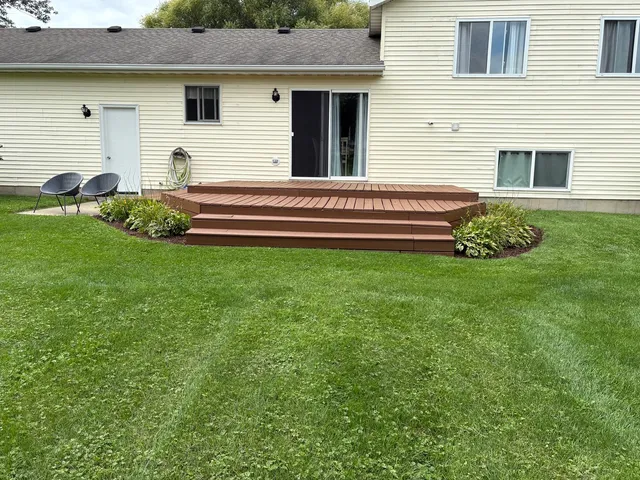 a backyard of a house with potted plants and a table