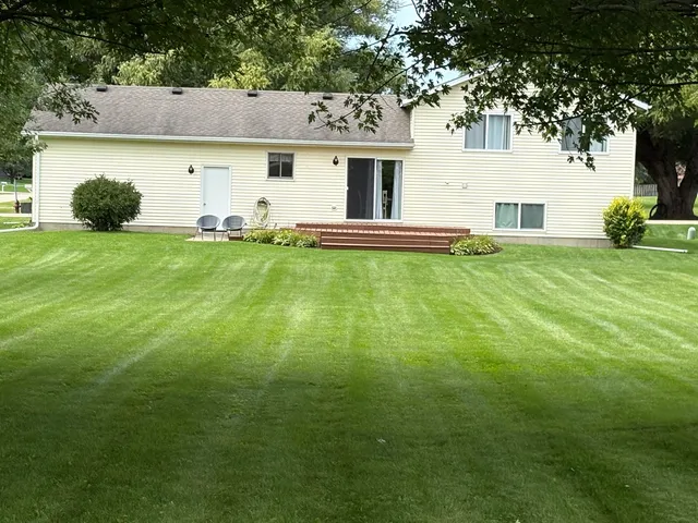 a view of a white house with a yard
