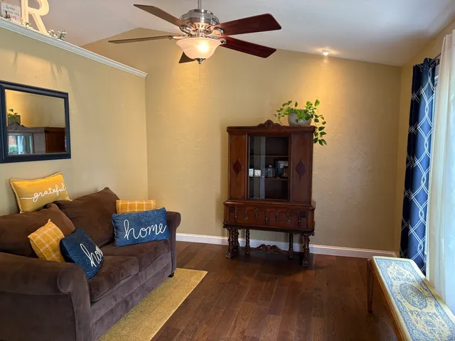 a living room with furniture and a wooden floor