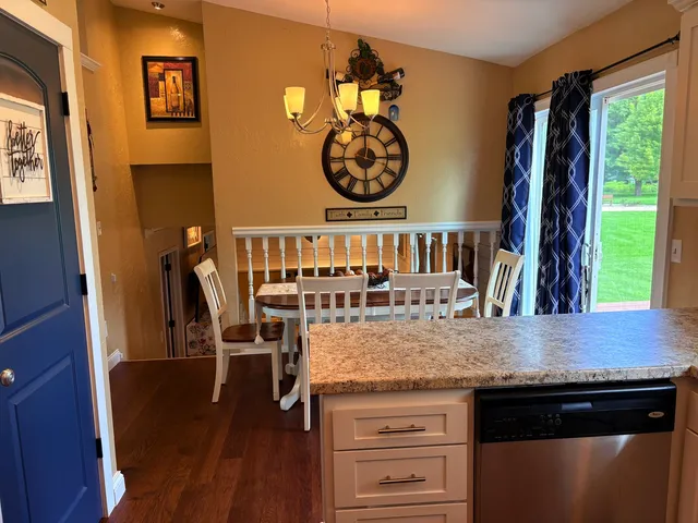 a kitchen with a table chairs and wooden floor