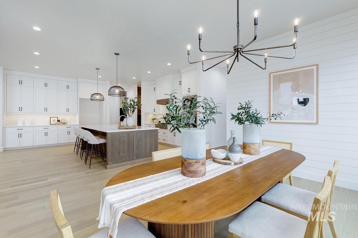 13624 North Ruffed Grouse Way Boise, ID 83714 - Photo 9 of 41 Dining room with light wood finished floors, a chandelier, recessed lighting, and wood walls