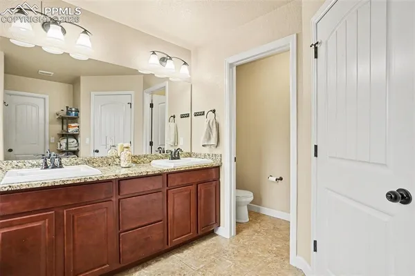a bathroom with a double vanity sink and mirror with shower