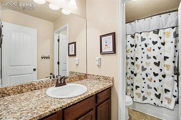 a bathroom with a granite countertop sink and a mirror