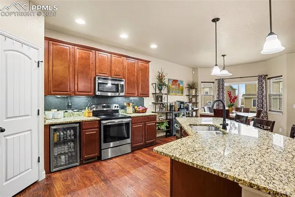 a kitchen with stainless steel appliances granite countertop sink stove and refrigerator