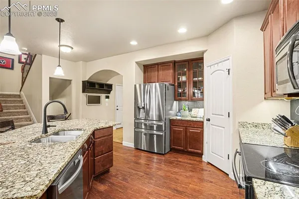 a kitchen with stainless steel appliances granite countertop a sink stove and refrigerator