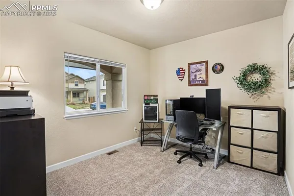 a view of a workspace with furniture and a window