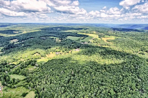 a view of a studio with lots of furniture and a wooden floor