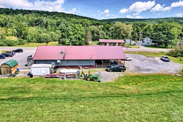 a view of a swimming pool with lawn chairs and a yard