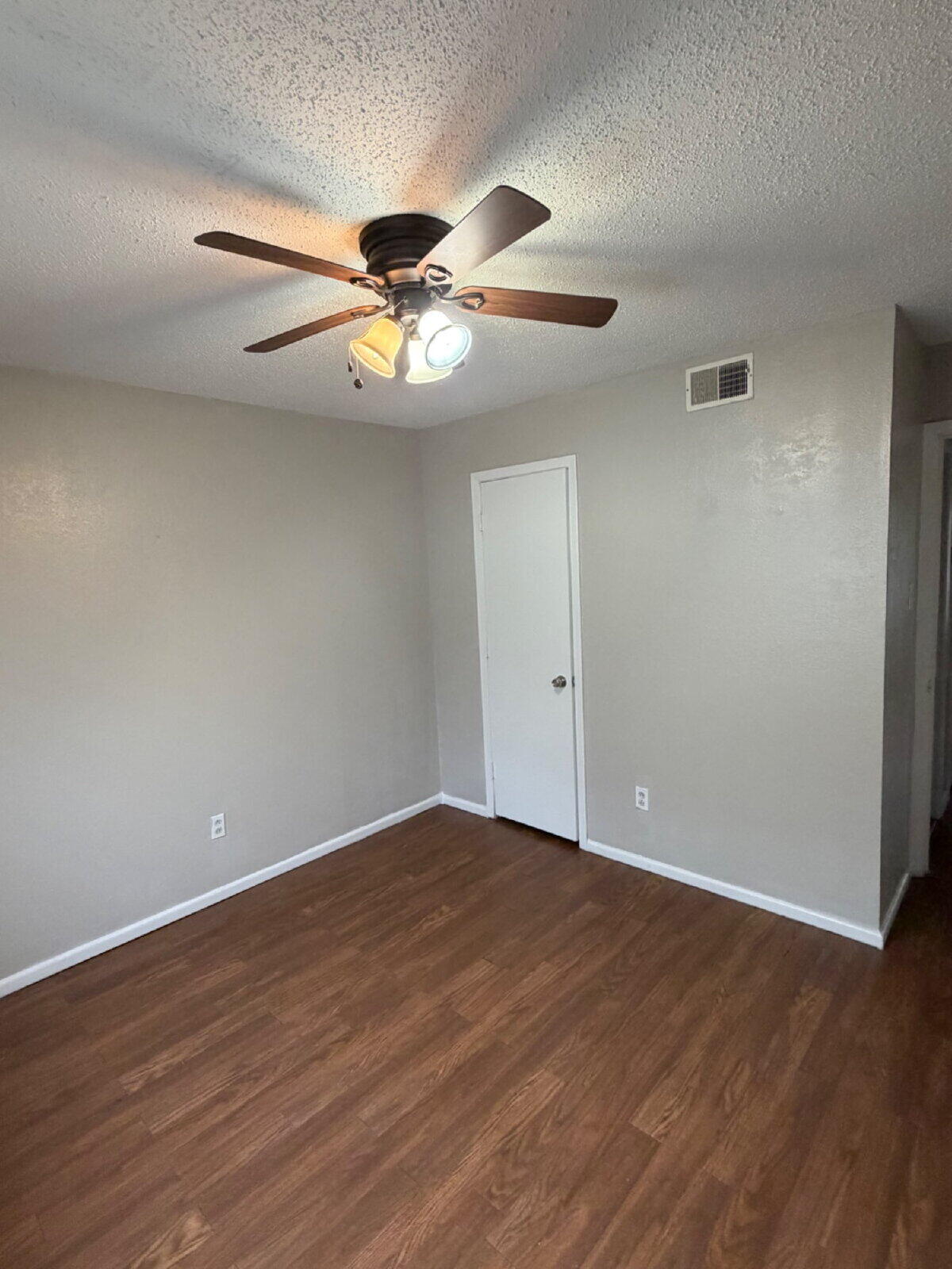 3211 35th Street, Unit E Lubbock, TX 79413 - Photo 11 of 13 a view of an empty room with wooden floor