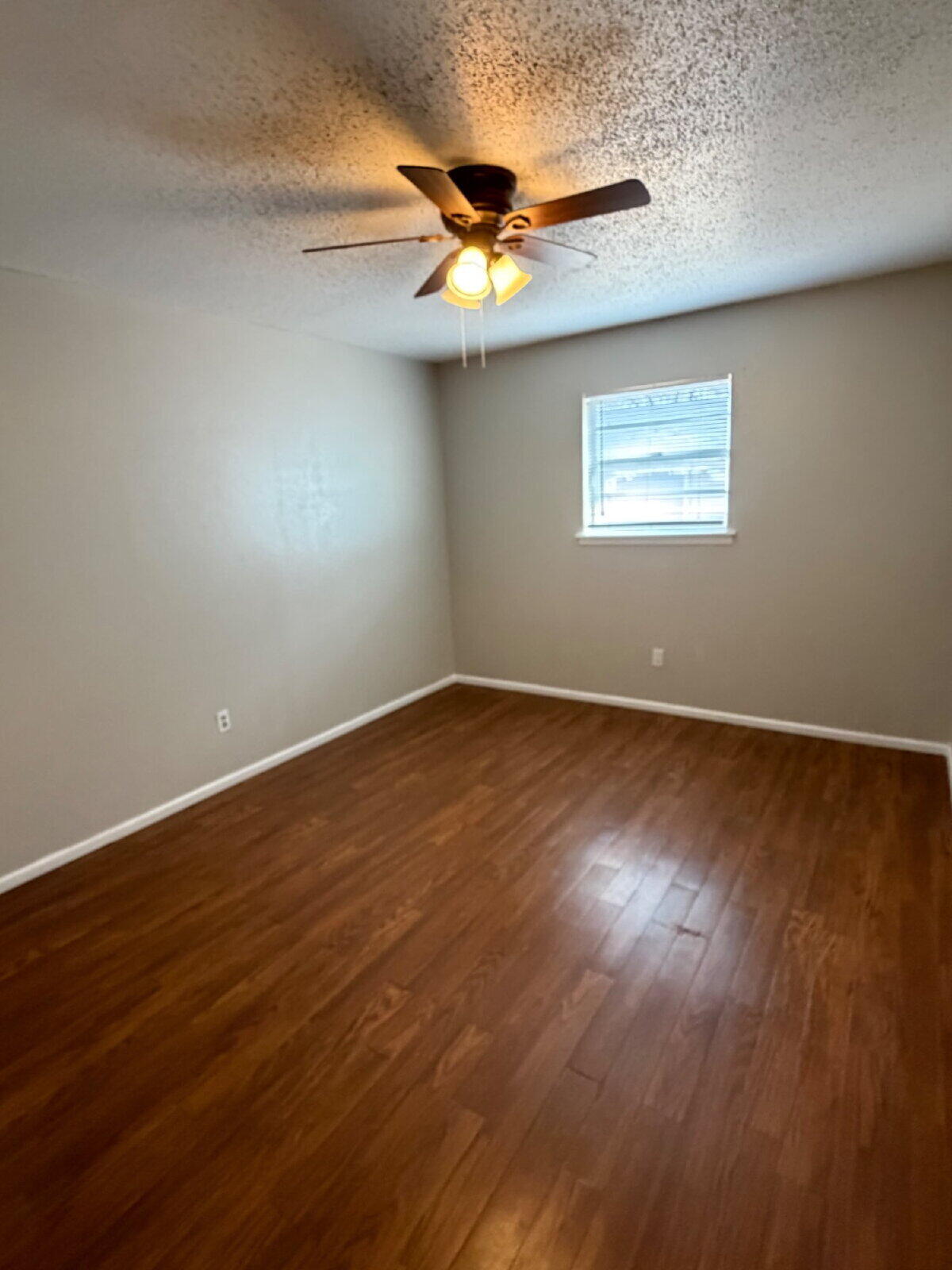 3211 35th Street, Unit E Lubbock, TX 79413 - Photo 12 of 13 a view of an empty room with wooden floor