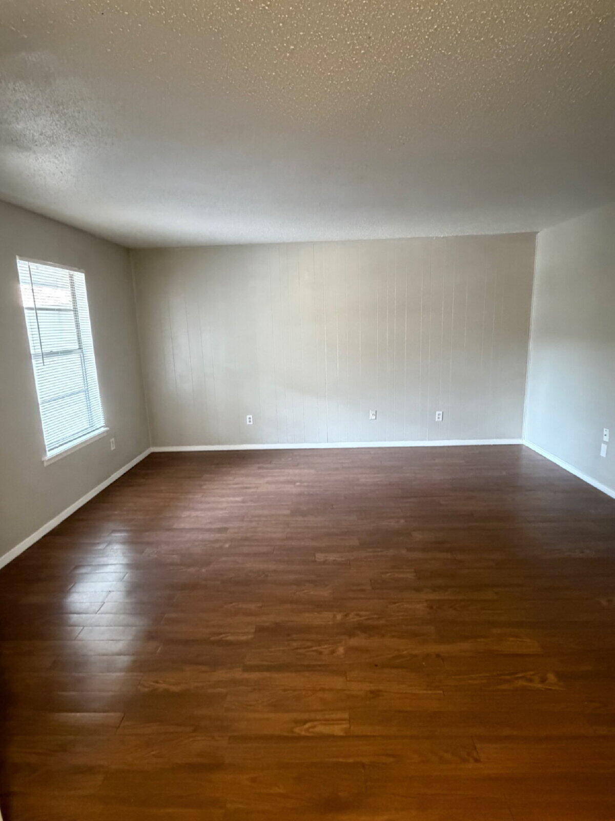 3211 35th Street, Unit E Lubbock, TX 79413 - Photo 3 of 13 wooden floor in an empty room with a window