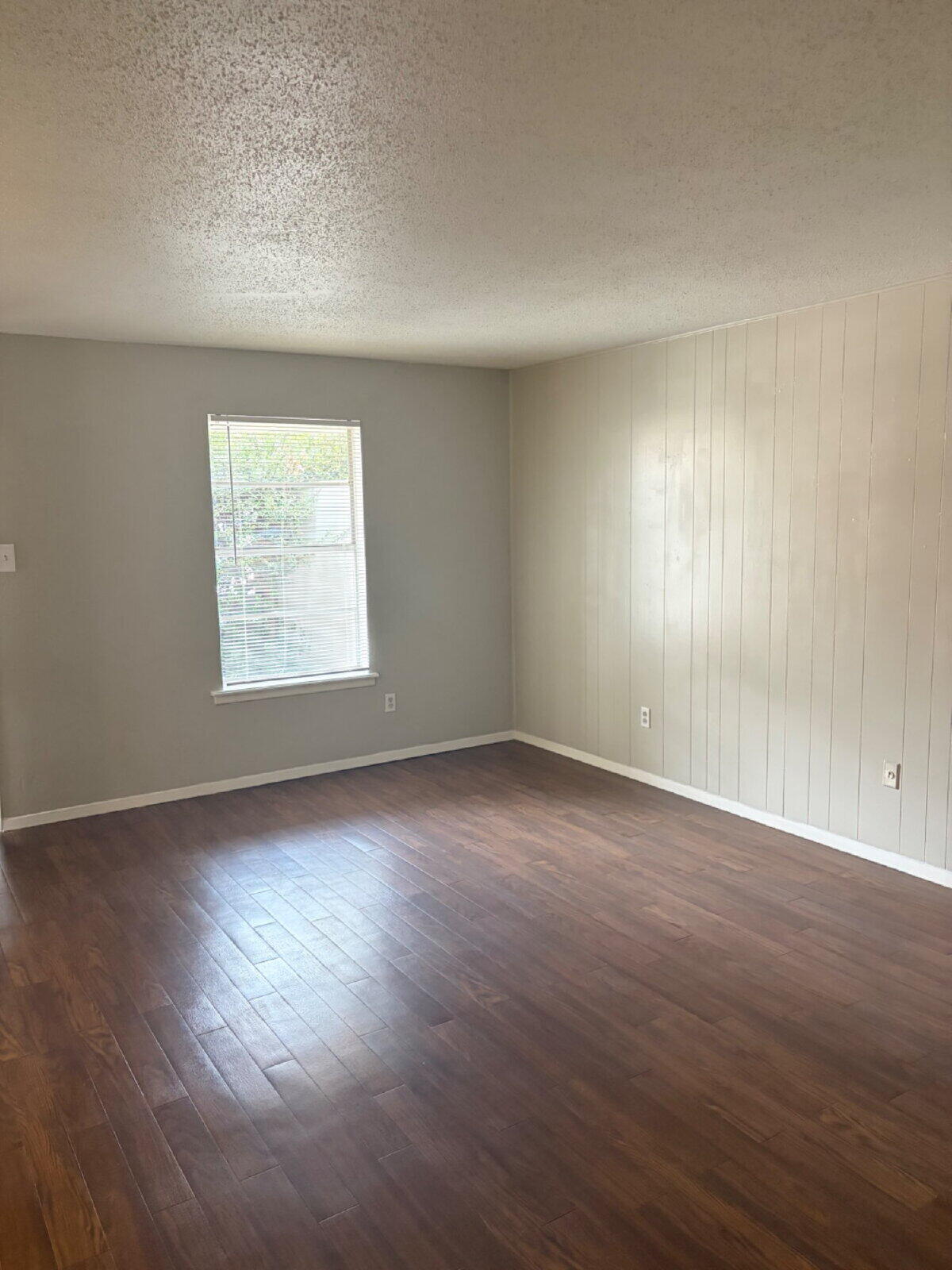 3211 35th Street, Unit E Lubbock, TX 79413 - Photo 4 of 13 an empty room with wooden floor and windows
