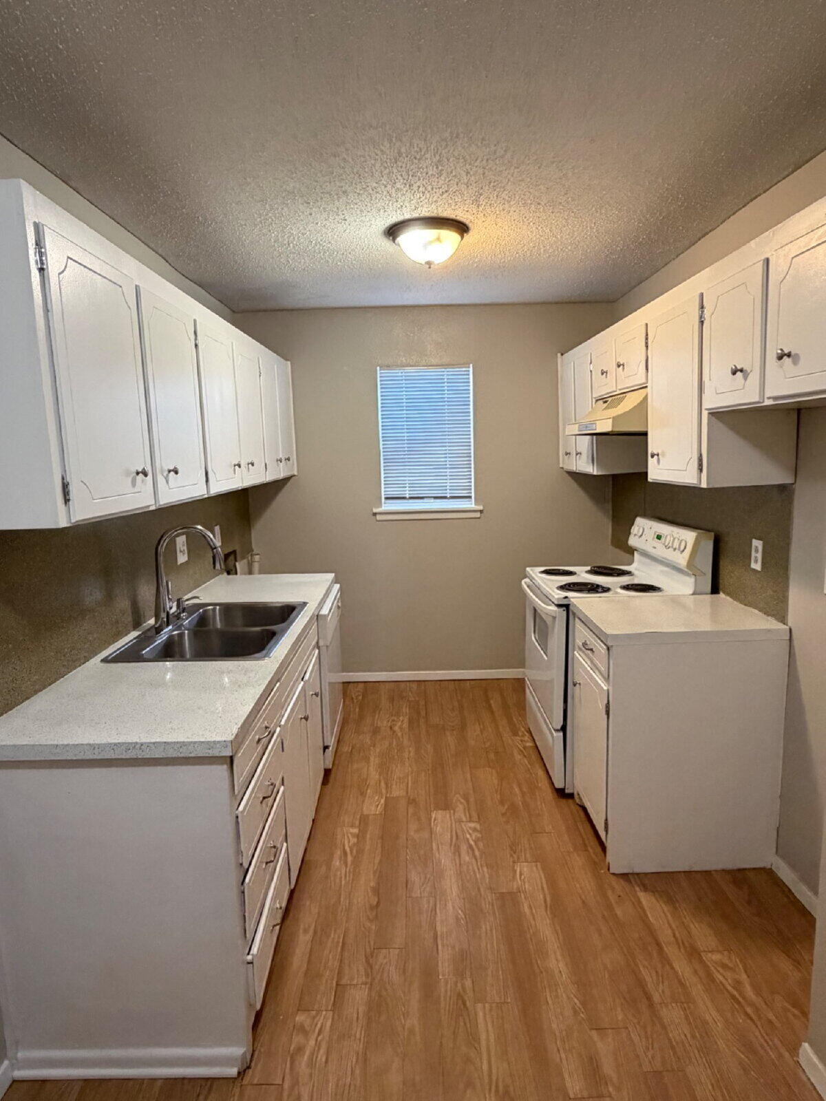3211 35th Street, Unit E Lubbock, TX 79413 - Photo 5 of 13 a kitchen that has a sink and a stove in it