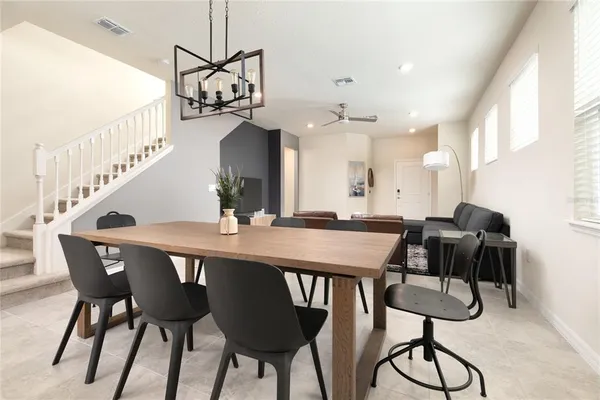 a view of a dining room and livingroom with furniture wooden floor a chandelier