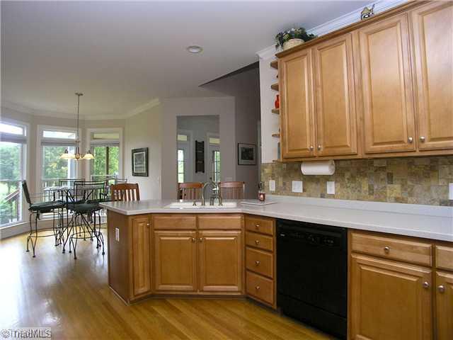 6004 Chalet Drive Oak Ridge, NC 27310 - Photo 4 of 16 Kitchen. Awesome Kitchen with eat-in/ Breakfast area, solid- surface coutertops, tile backsplash, raised panel maple cabinets & more!