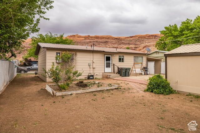 527 Palisade Drive Moab, UT 84532 - Photo 22 of 51 Rear view of house with fence, a patio area, metal roof, and a mountain view