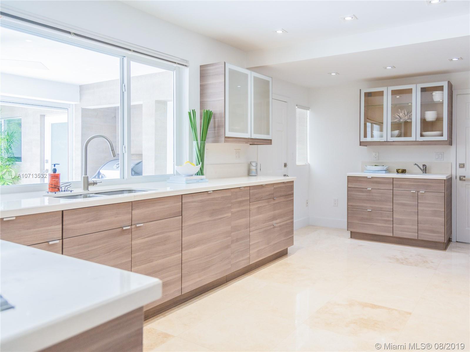 4765 Lake Road Miami, FL 33137 - Photo 19 of 30 a bathroom with a double vanity sink a mirror and a bathtub