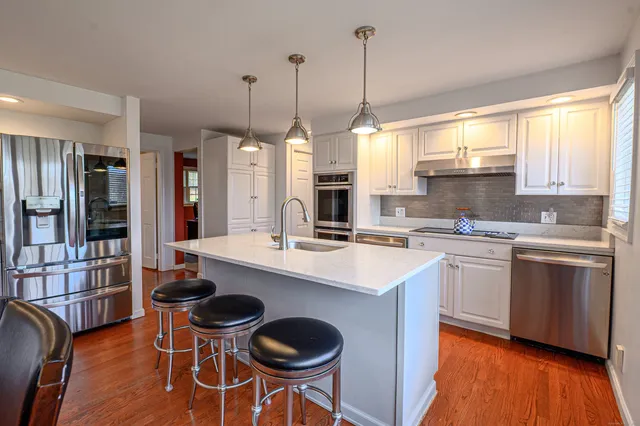 a kitchen with appliances a sink and cabinets