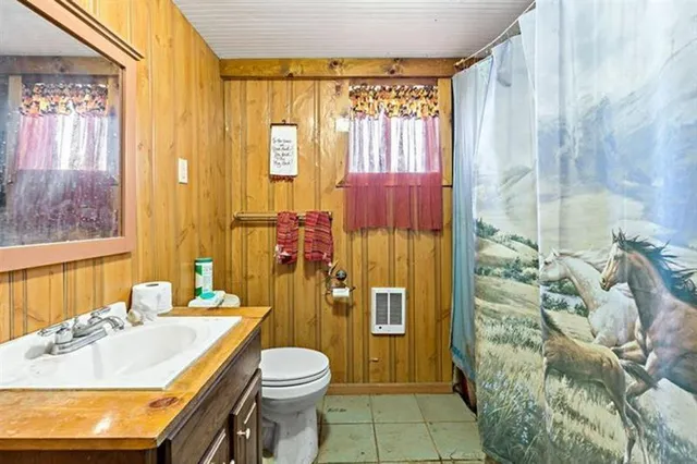 a bathroom with a granite countertop bathtub sink vanity mirror and toilet