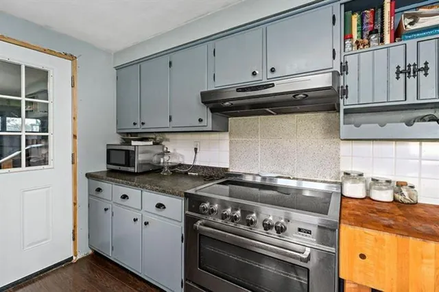 a stove top oven sitting inside of a kitchen